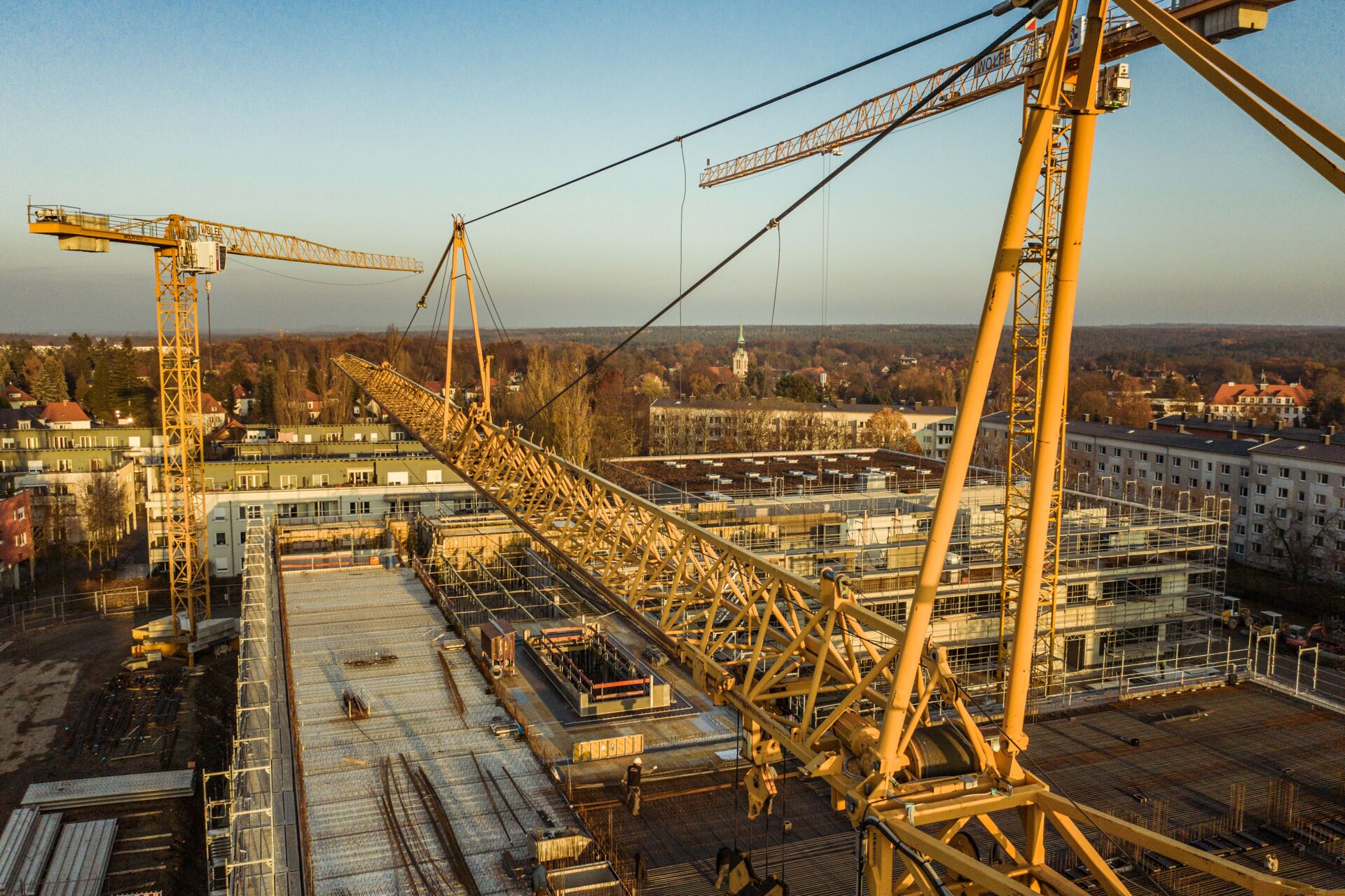Eine Aufnahme von zwei Kranen auf einer Baustelle, im Kontext der Hans Müller GmbH – Bauunternehmen.