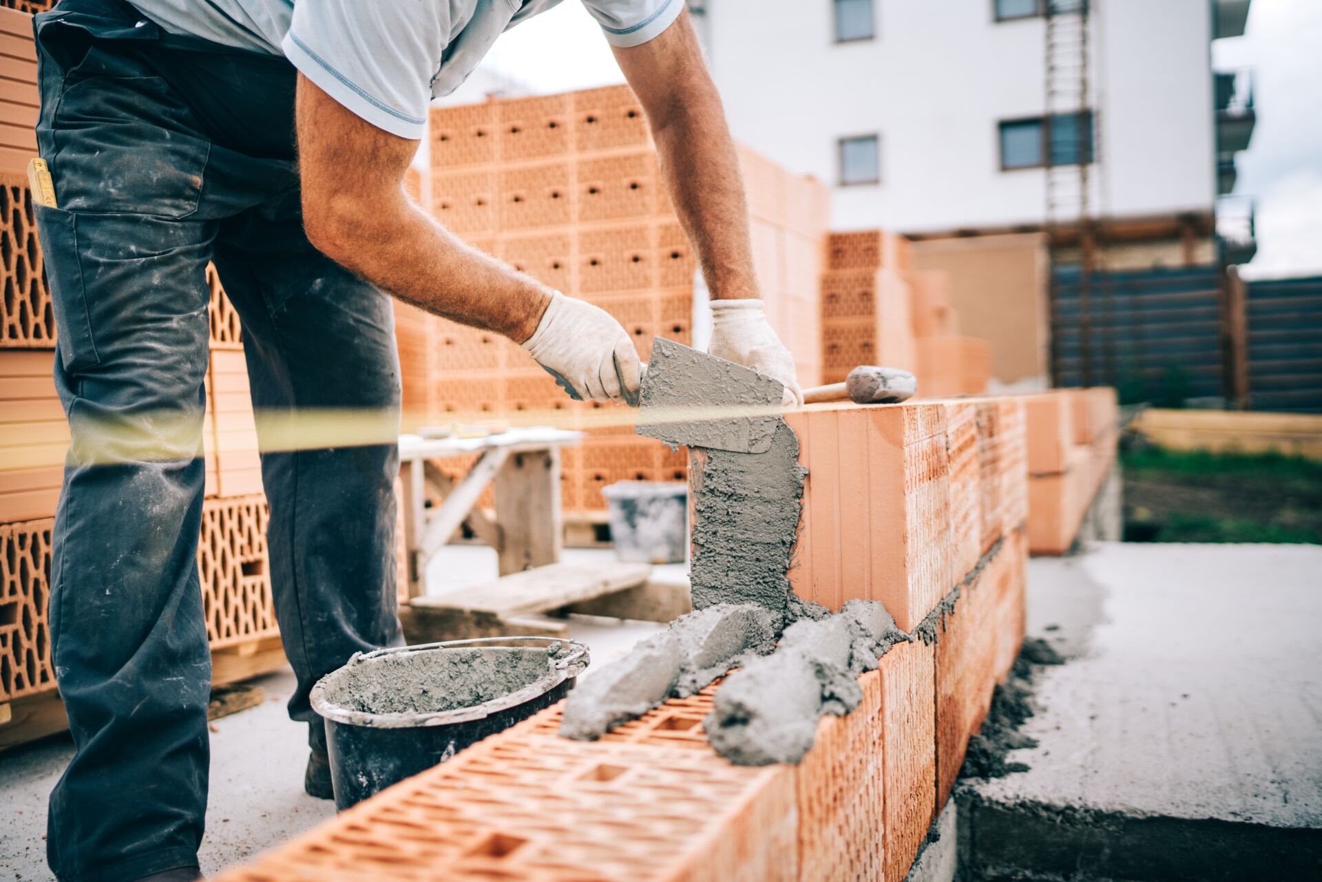 Ein Maurer mauert eine Ziegelwand, im Kontext der Hans Müller GmbH – Bauunternehmen